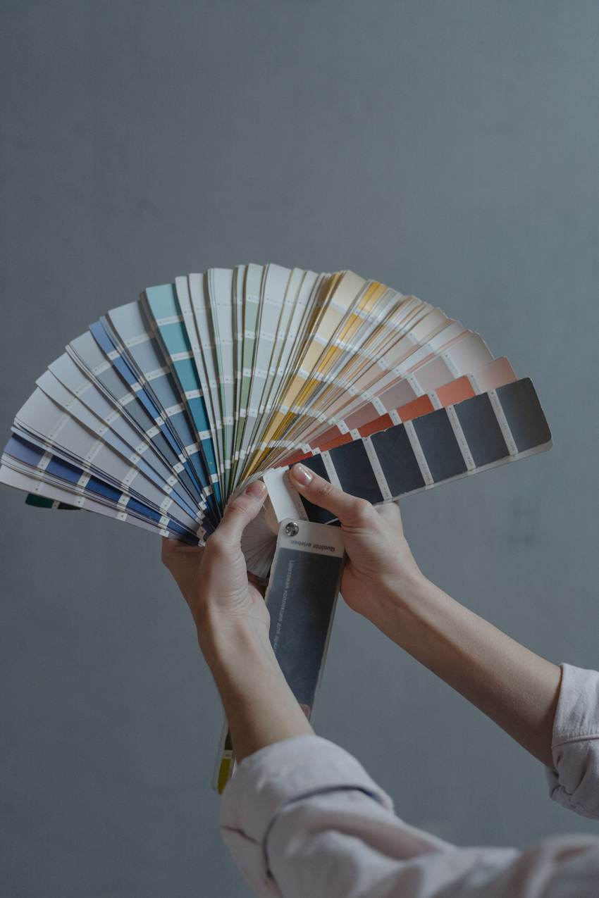 Hands fanning out a deck of paint color samples