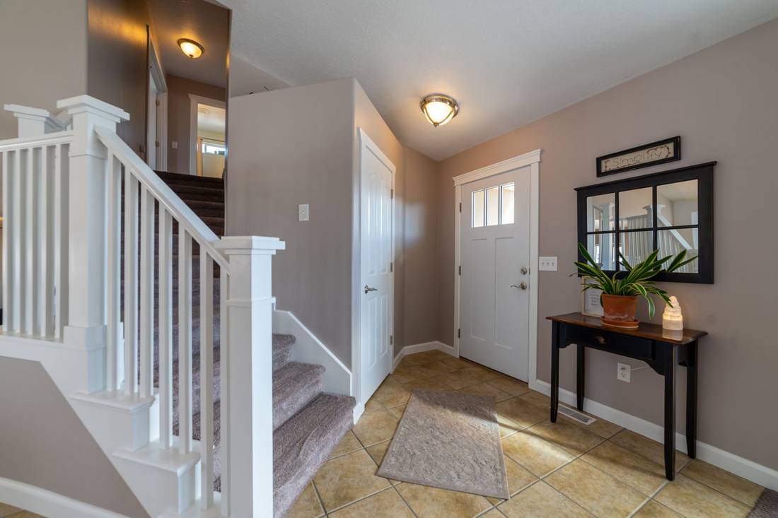 Entryway with a white stair railing and front door